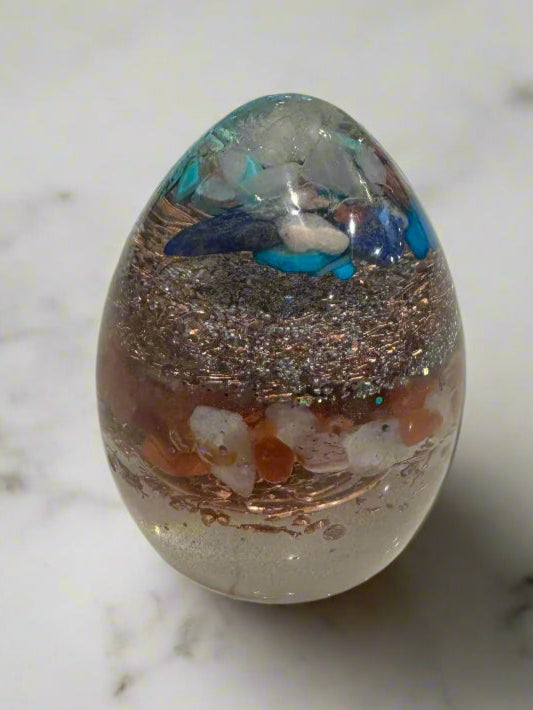 Decorative glass sphere with multicolored interior on a marble floor